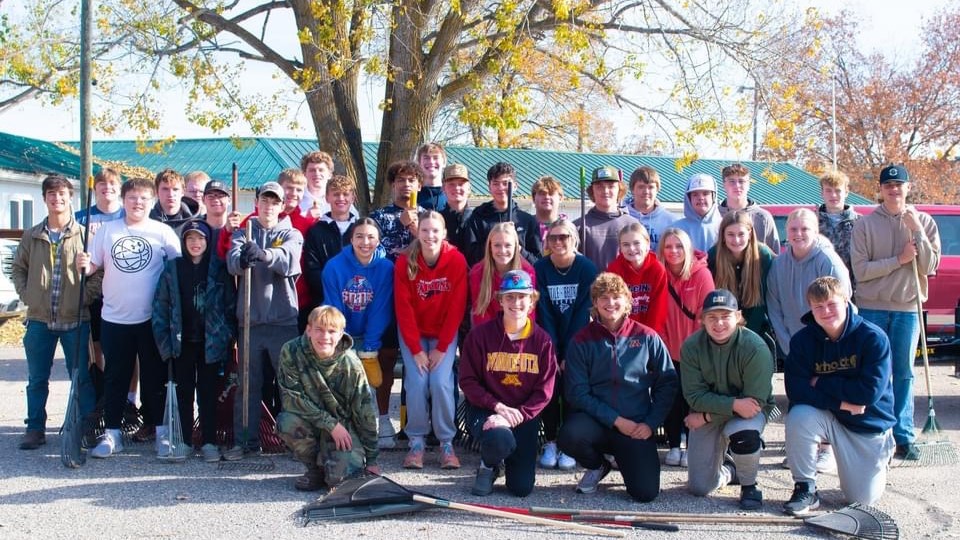 Athletes, coaches and parents do a fall clean up in  the community